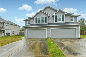 view of front facade with an attached garage, driveway, and a front lawn