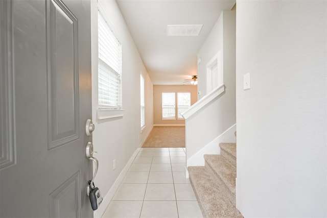 doorway with light tile patterned floors, baseboards, visible vents, a ceiling fan, and stairway