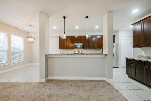 kitchen with light tile patterned floors, stainless steel appliances, dark brown cabinets, and light colored carpet