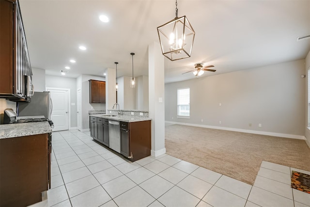 kitchen with stainless steel appliances, light carpet, a sink, and light tile patterned flooring