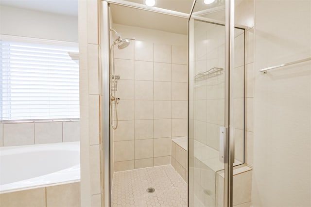 bathroom featuring a garden tub and a shower stall