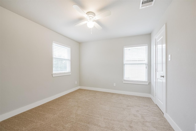 carpeted spare room with ceiling fan, visible vents, and baseboards