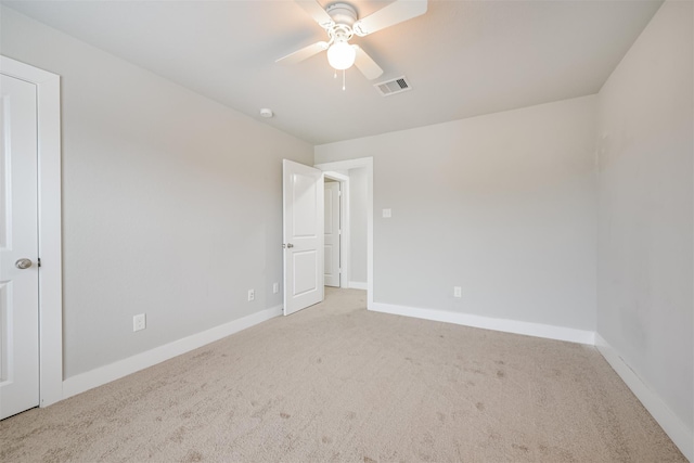 carpeted spare room featuring visible vents, ceiling fan, and baseboards