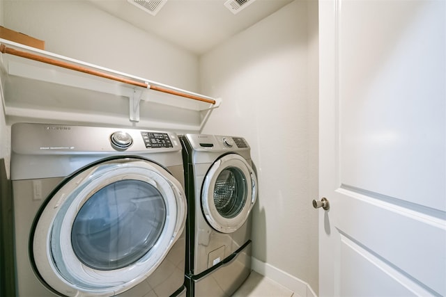 clothes washing area featuring laundry area, baseboards, visible vents, and washer and dryer