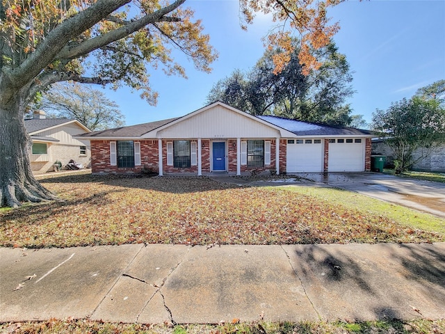 ranch-style home with a garage, concrete driveway, brick siding, and a front lawn