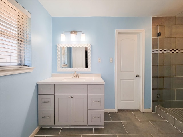 full bath with tile patterned flooring, a shower stall, vanity, and baseboards