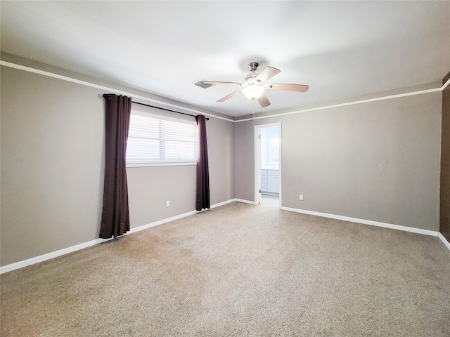 spare room featuring baseboards, a ceiling fan, visible vents, and light colored carpet