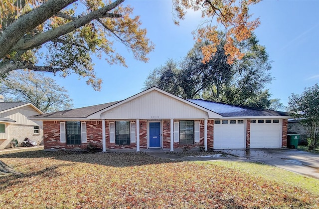 ranch-style home with a garage, a front yard, concrete driveway, and brick siding