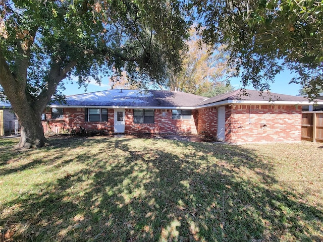 single story home with brick siding, a front lawn, and fence