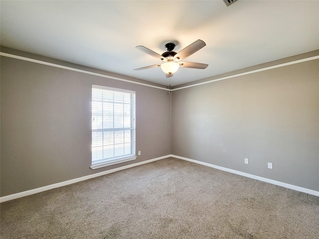 spare room featuring carpet, a ceiling fan, and baseboards