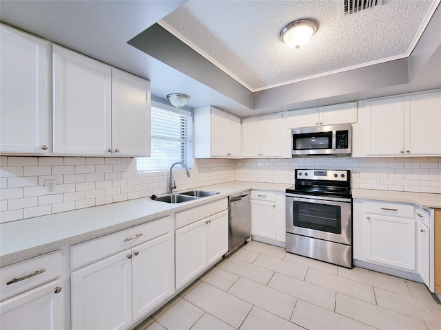 kitchen featuring stainless steel appliances, a sink, visible vents, and decorative backsplash