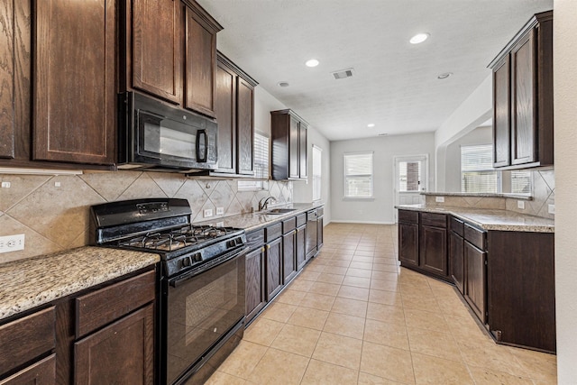 kitchen featuring visible vents, dark brown cabinetry, black appliances, and light tile patterned flooring