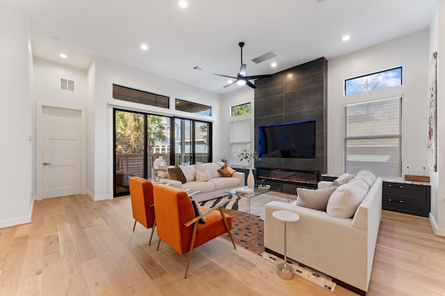 living area featuring visible vents, light wood-style floors, and a ceiling fan