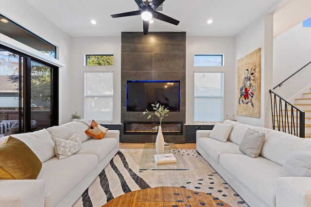 living room with stairway, recessed lighting, a fireplace, and ceiling fan