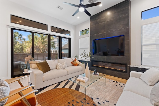 living area featuring recessed lighting, visible vents, a large fireplace, and ceiling fan