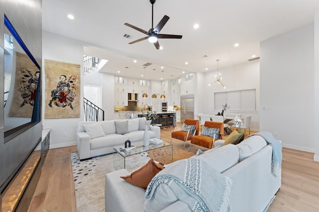 living room featuring light wood finished floors, stairway, recessed lighting, and visible vents