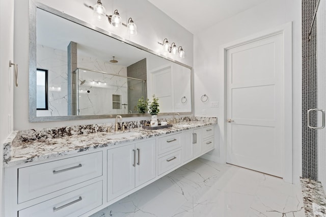 bathroom featuring a marble finish shower, marble finish floor, double vanity, and a sink