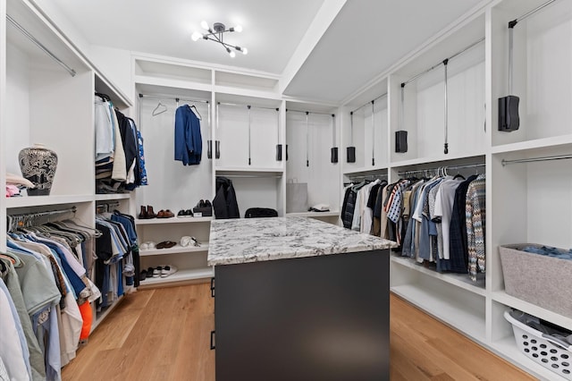 walk in closet with light wood-style floors