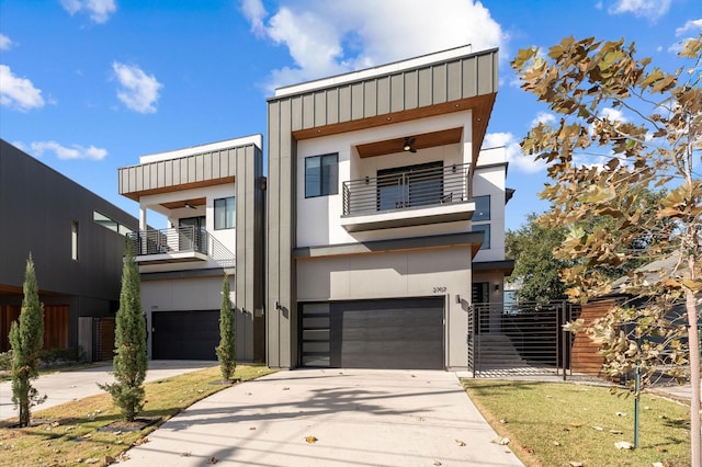 contemporary house with concrete driveway, a balcony, an attached garage, and stucco siding