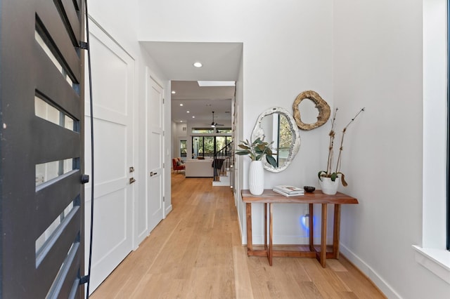 hallway with recessed lighting, baseboards, and light wood finished floors