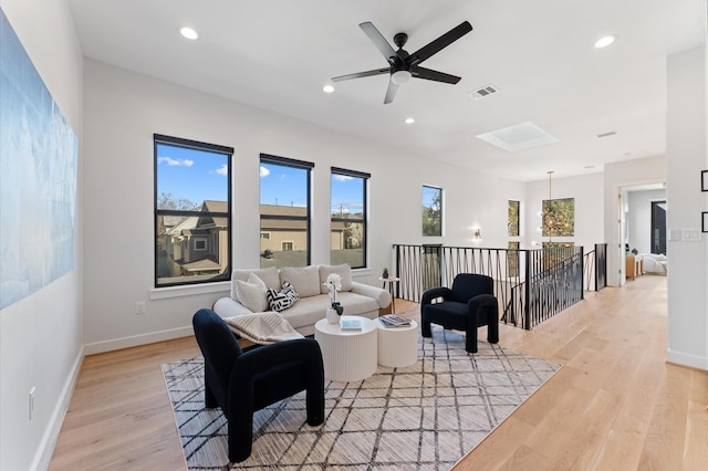 living area featuring recessed lighting, visible vents, light wood-style flooring, and a skylight