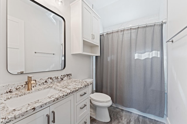 bathroom featuring a shower with shower curtain, toilet, and vanity