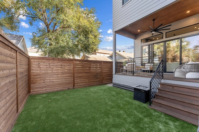 view of yard with a fenced backyard and a ceiling fan