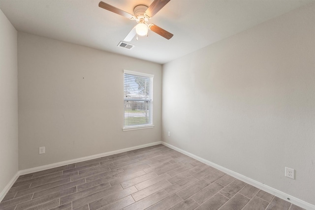 unfurnished room with baseboards, wood finished floors, visible vents, and a ceiling fan