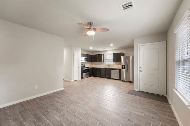 kitchen with stainless steel appliances, light countertops, visible vents, light wood-type flooring, and baseboards