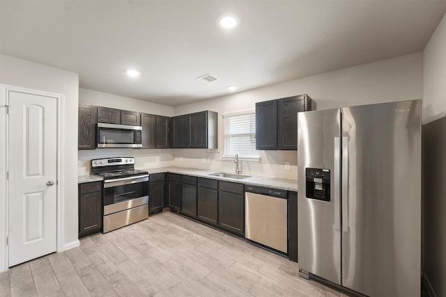 kitchen with visible vents, light wood-style flooring, stainless steel appliances, a sink, and recessed lighting