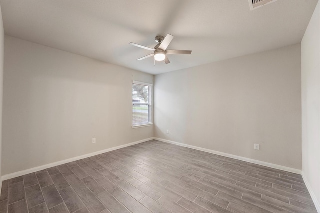 unfurnished room featuring ceiling fan, dark wood finished floors, visible vents, and baseboards