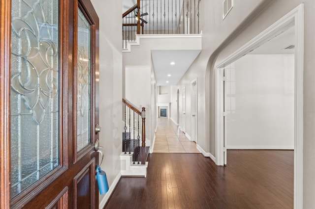 entryway featuring stairs, recessed lighting, visible vents, baseboards, and hardwood / wood-style flooring