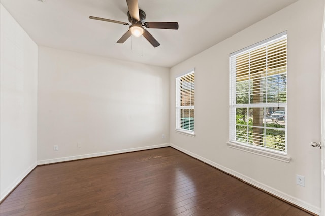 spare room with ceiling fan, dark wood-style flooring, and baseboards