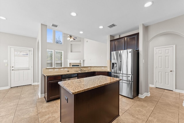 kitchen with stainless steel refrigerator with ice dispenser, ceiling fan, a sink, dark brown cabinets, and dishwashing machine