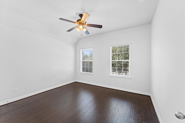 spare room with lofted ceiling, a ceiling fan, baseboards, and dark wood-style flooring