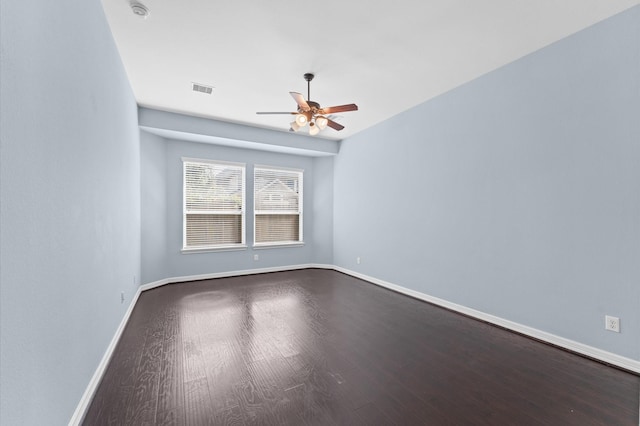 unfurnished room with ceiling fan, visible vents, baseboards, and dark wood-style flooring