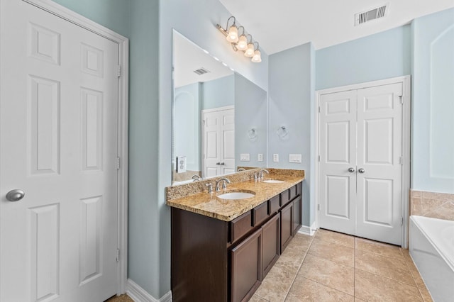 full bathroom featuring a bath, tile patterned flooring, visible vents, and a sink