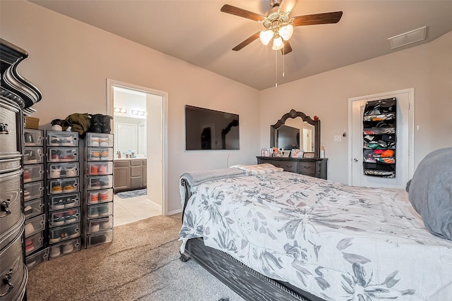 bedroom with visible vents, a ceiling fan, connected bathroom, light colored carpet, and a closet