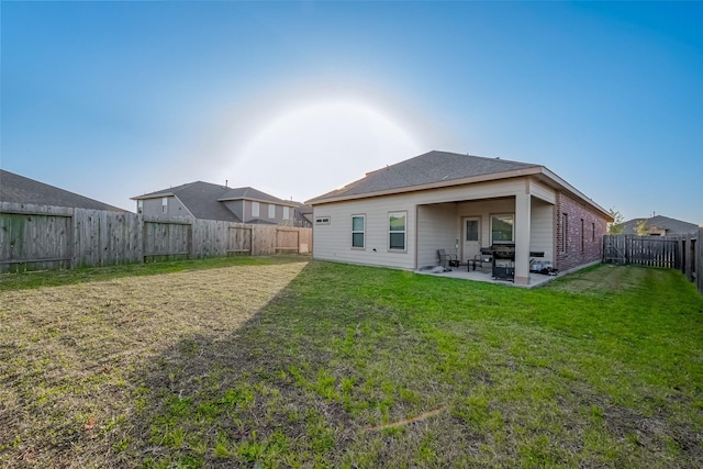 back of property featuring a patio area, a fenced backyard, and a lawn