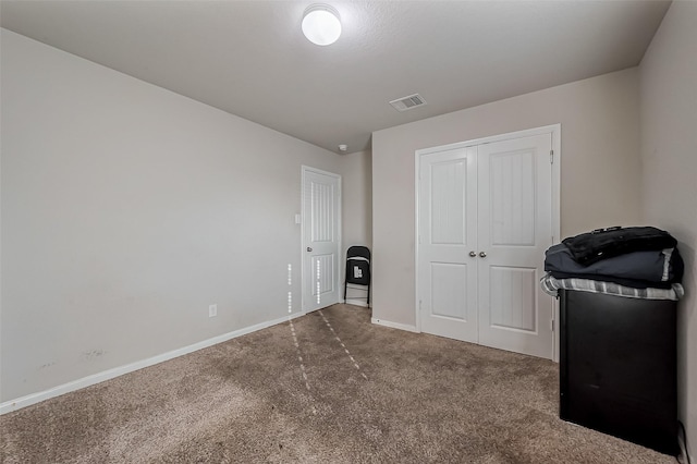 unfurnished bedroom featuring carpet, a closet, visible vents, and baseboards