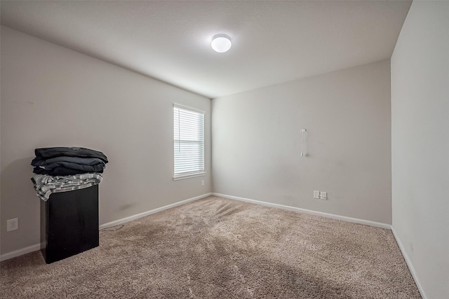 carpeted empty room featuring baseboards