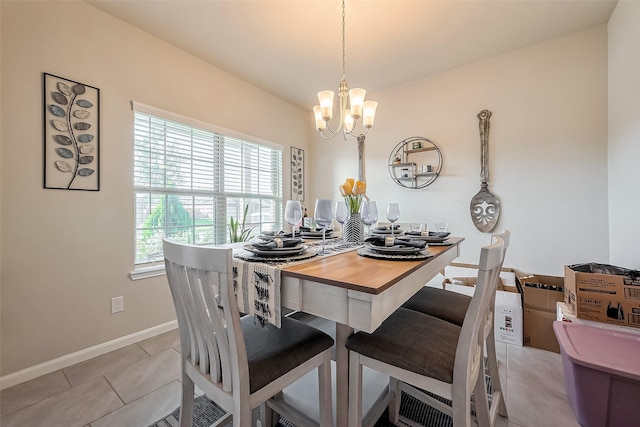 dining area with a chandelier, light tile patterned floors, and baseboards