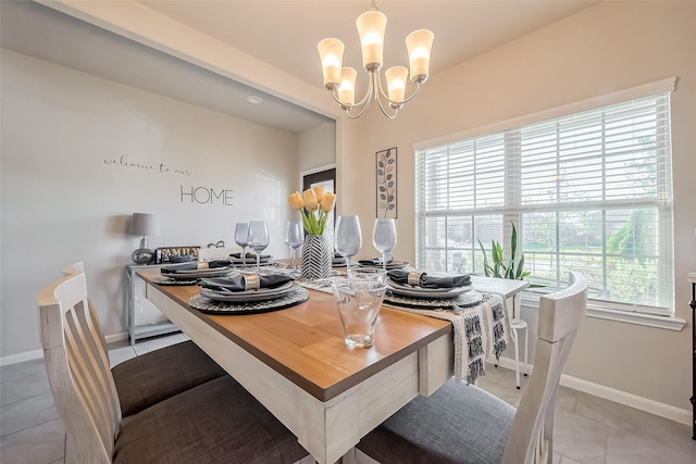 dining room featuring light tile patterned flooring, a notable chandelier, and baseboards