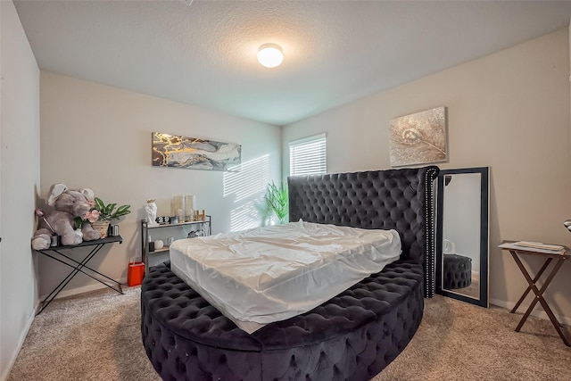 carpeted bedroom with a textured ceiling and baseboards