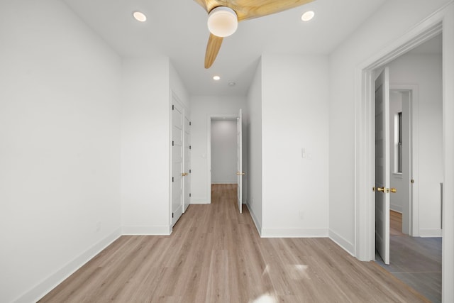 corridor featuring baseboards, light wood-type flooring, and recessed lighting