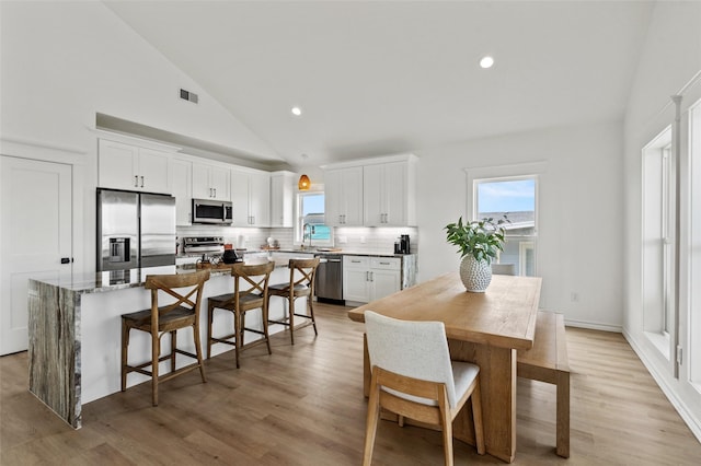 4214 Jackson Dr, Galveston, TX 77554 - dining area featuring light wood-type flooring, a wealth of natural light, and visible vents