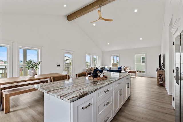 4214 Jackson Dr, Galveston, TX 77554 - kitchen featuring white cabinetry, open floor plan, light wood-type flooring, a center island, and beamed ceiling