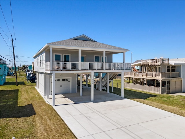 view of front of house featuring concrete driveway, a shingled roof, a carport, and a front yard