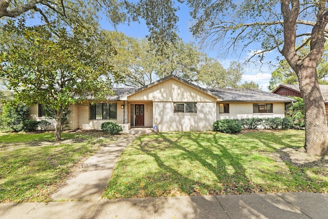 ranch-style home with brick siding, a front yard, and a shingled roof