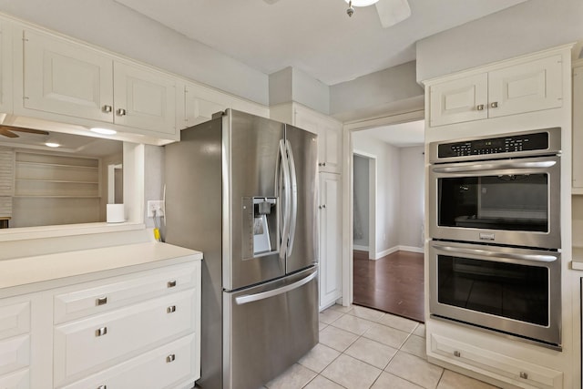 kitchen with light tile patterned floors, white cabinets, a ceiling fan, stainless steel appliances, and light countertops